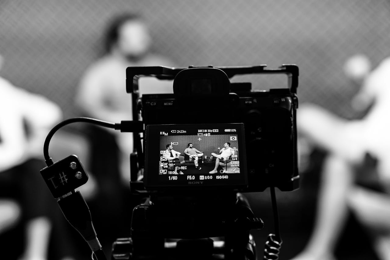 Camera capturing an indoor interview scene, in focus with a blurred background.